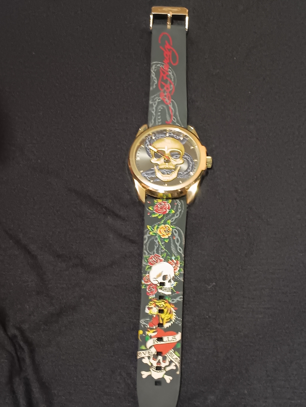 Ed Hardy Gold-Tone Skull Dial Watch with Black Strap and Red Accents